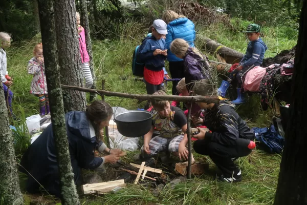 Ugunskura vietā mūs sagaida Kristīne, kura palīdzēs brūvēt zupu. Sākam ar uguns kurināšanu